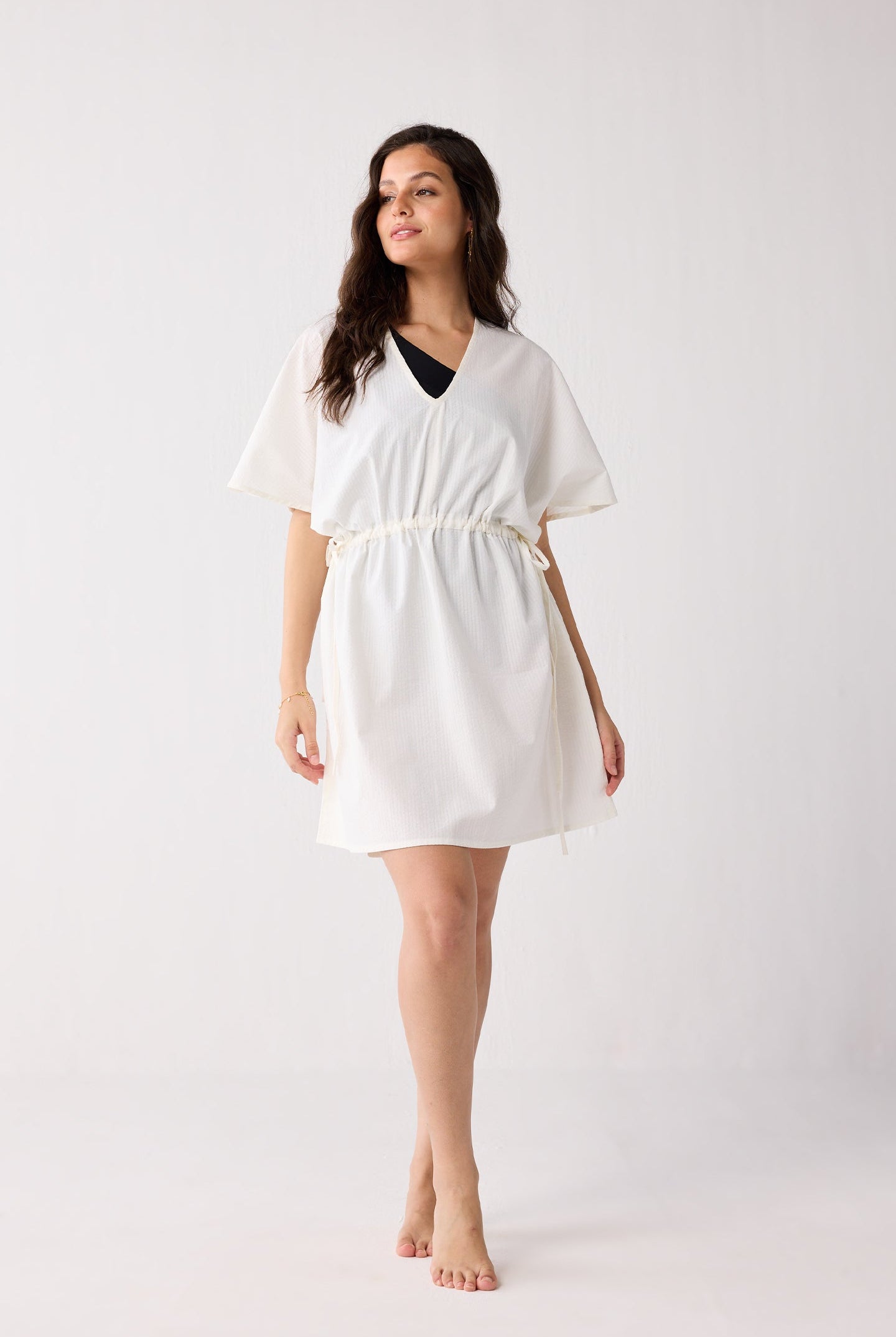 Woman wearing a white dress against a plain background