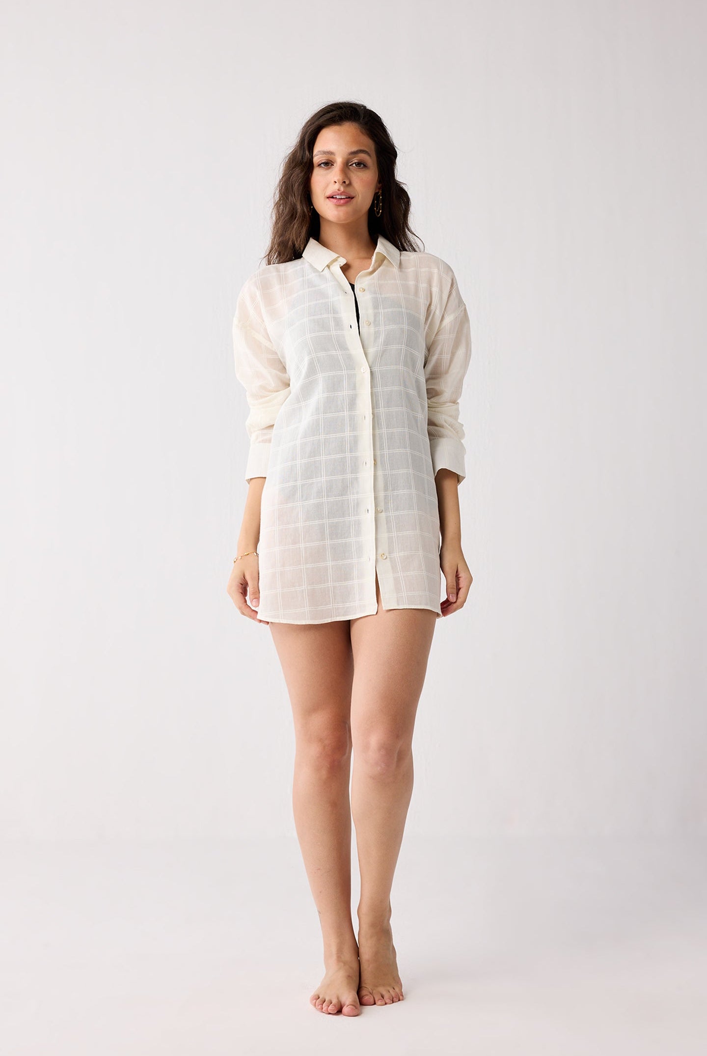 Woman wearing a white checkered shirt on a plain background