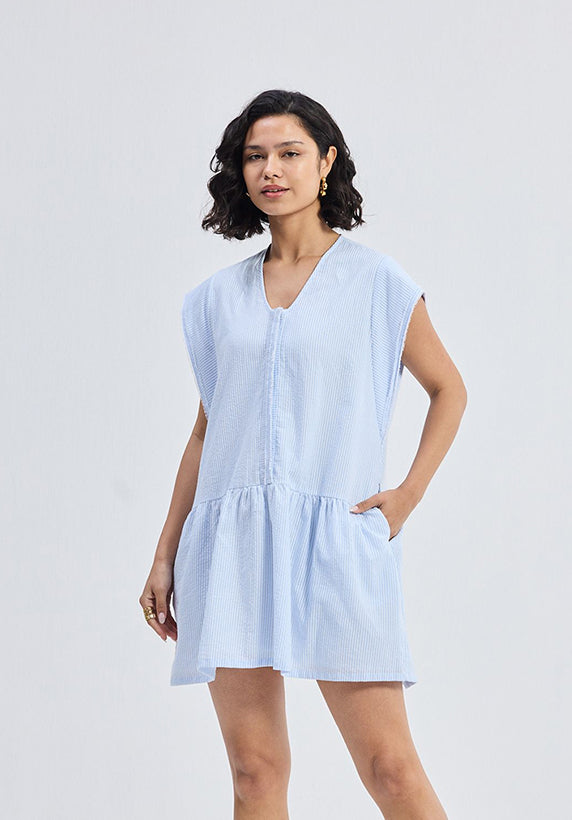 Woman wearing a light blue dress against a white background