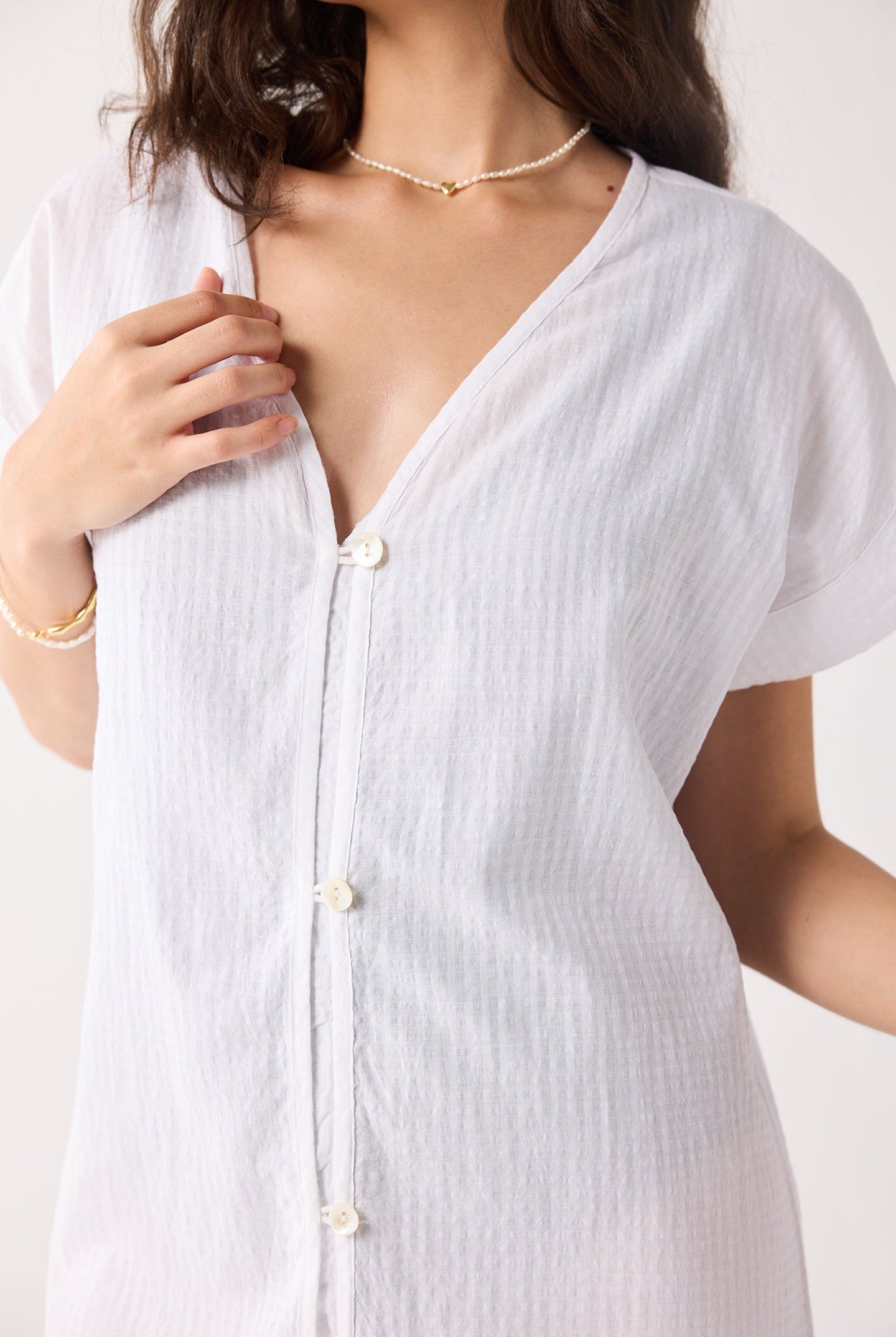 White button-up dress worn by a person on a white background
