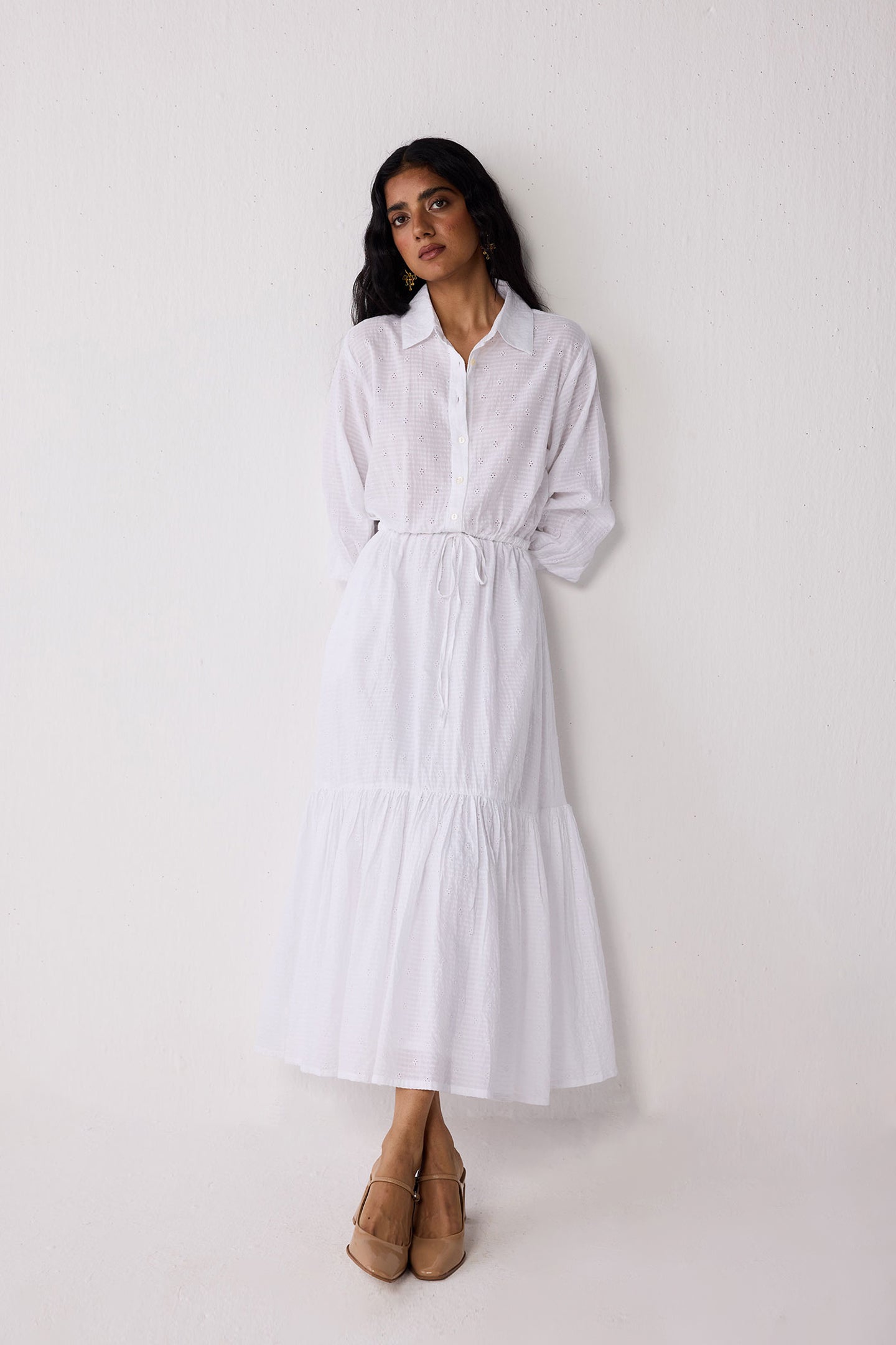 Woman wearing a white dress against a plain background