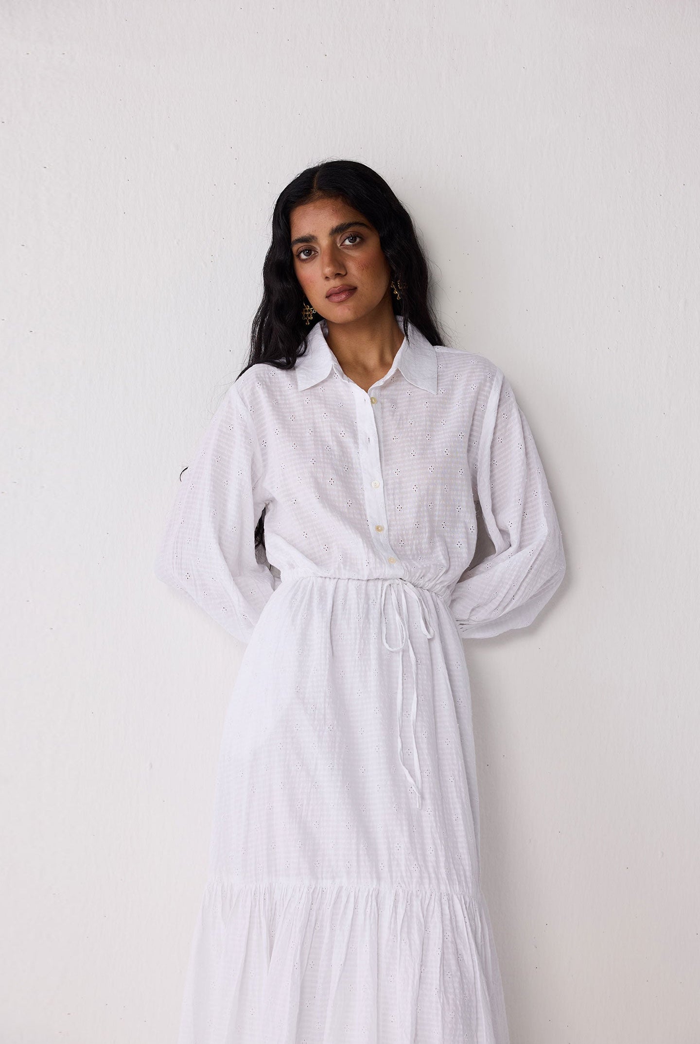 Woman wearing a white dress against a plain background