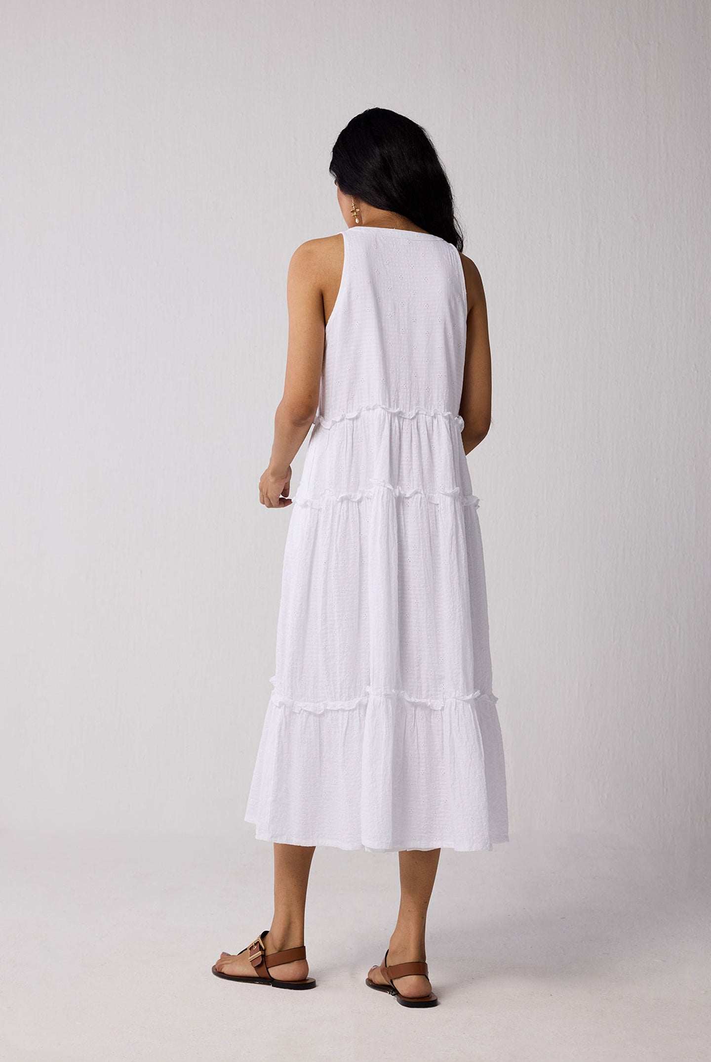 Woman wearing a white dress against a plain background