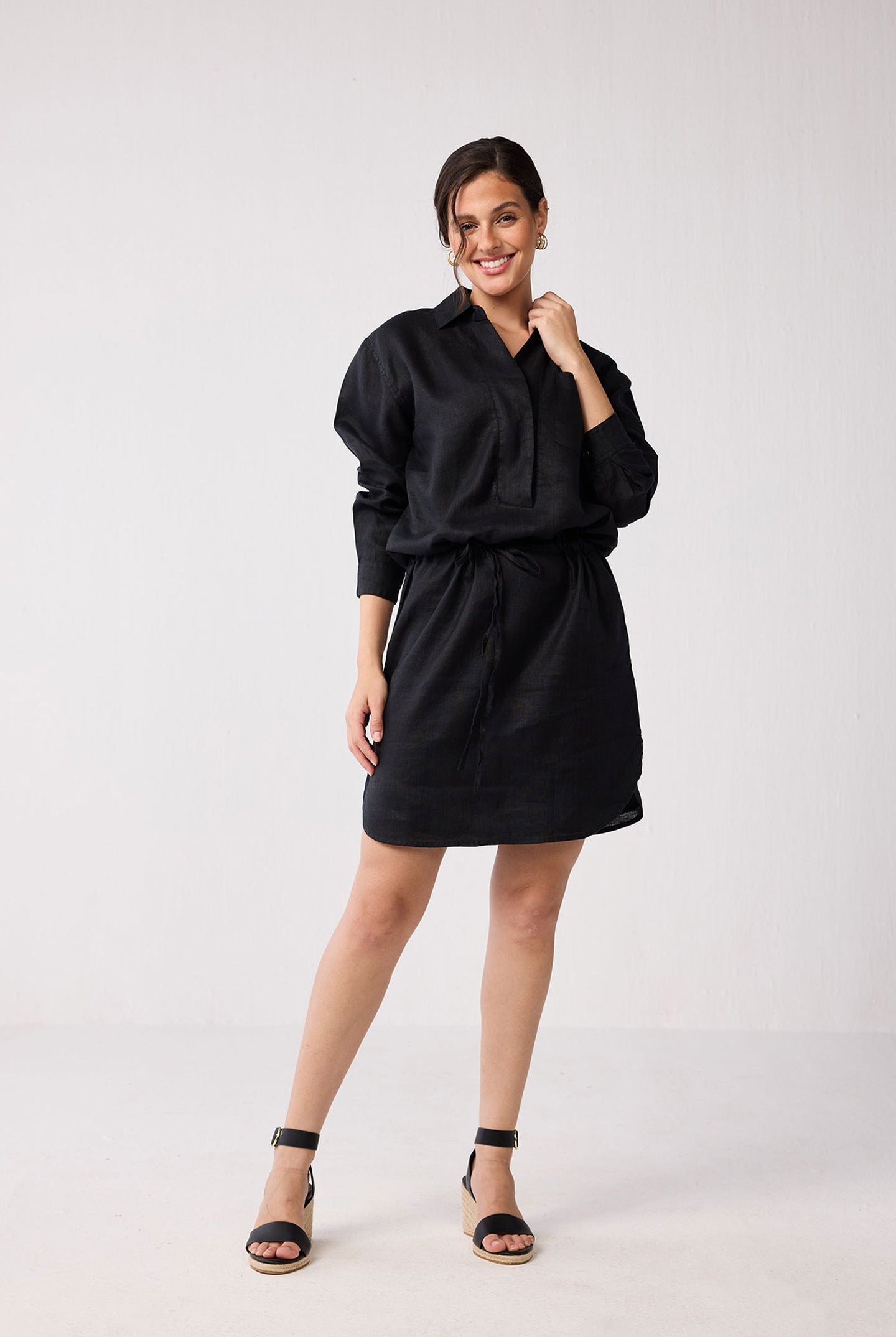 Woman wearing a black dress against a white background