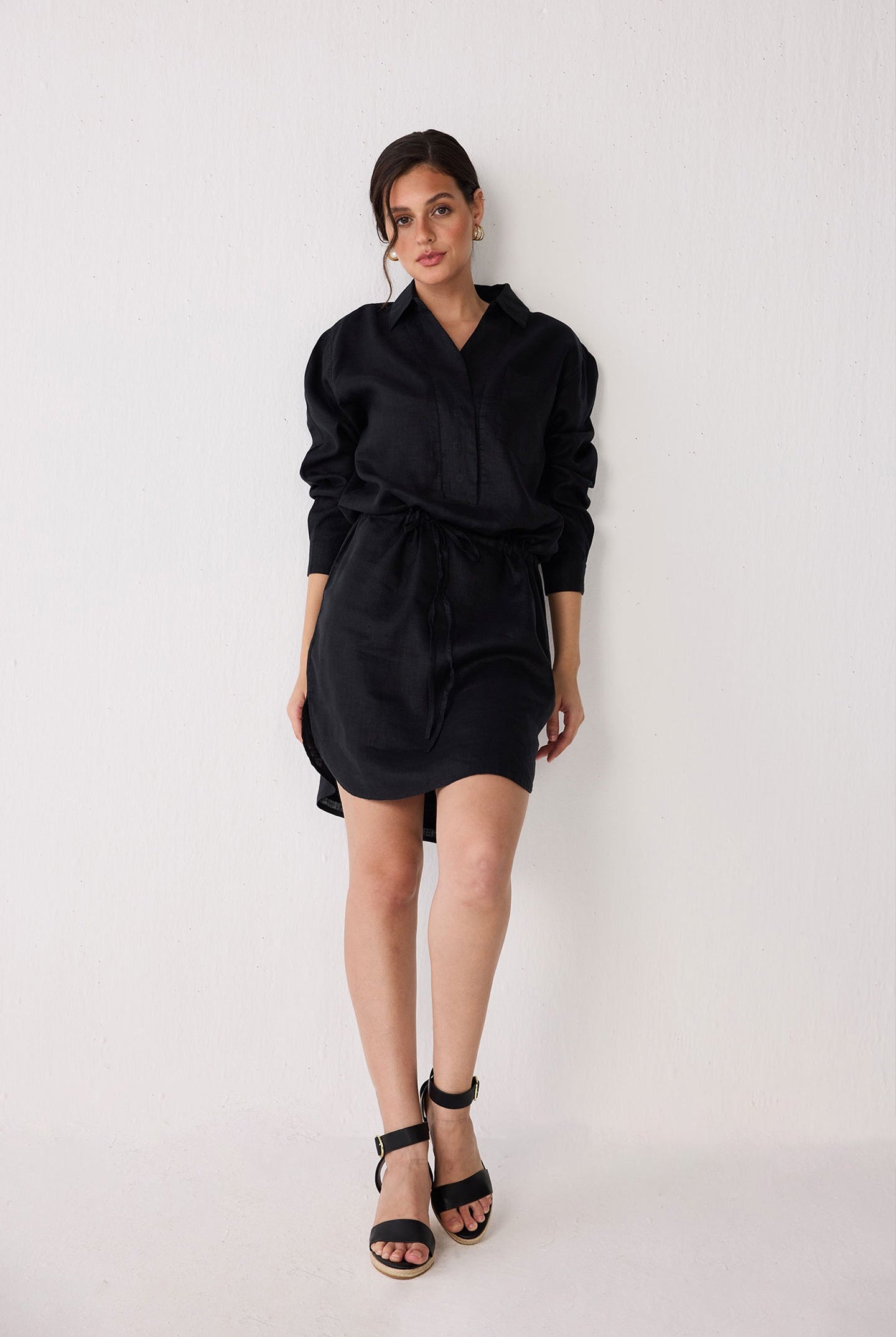 Woman wearing a black dress against a white background