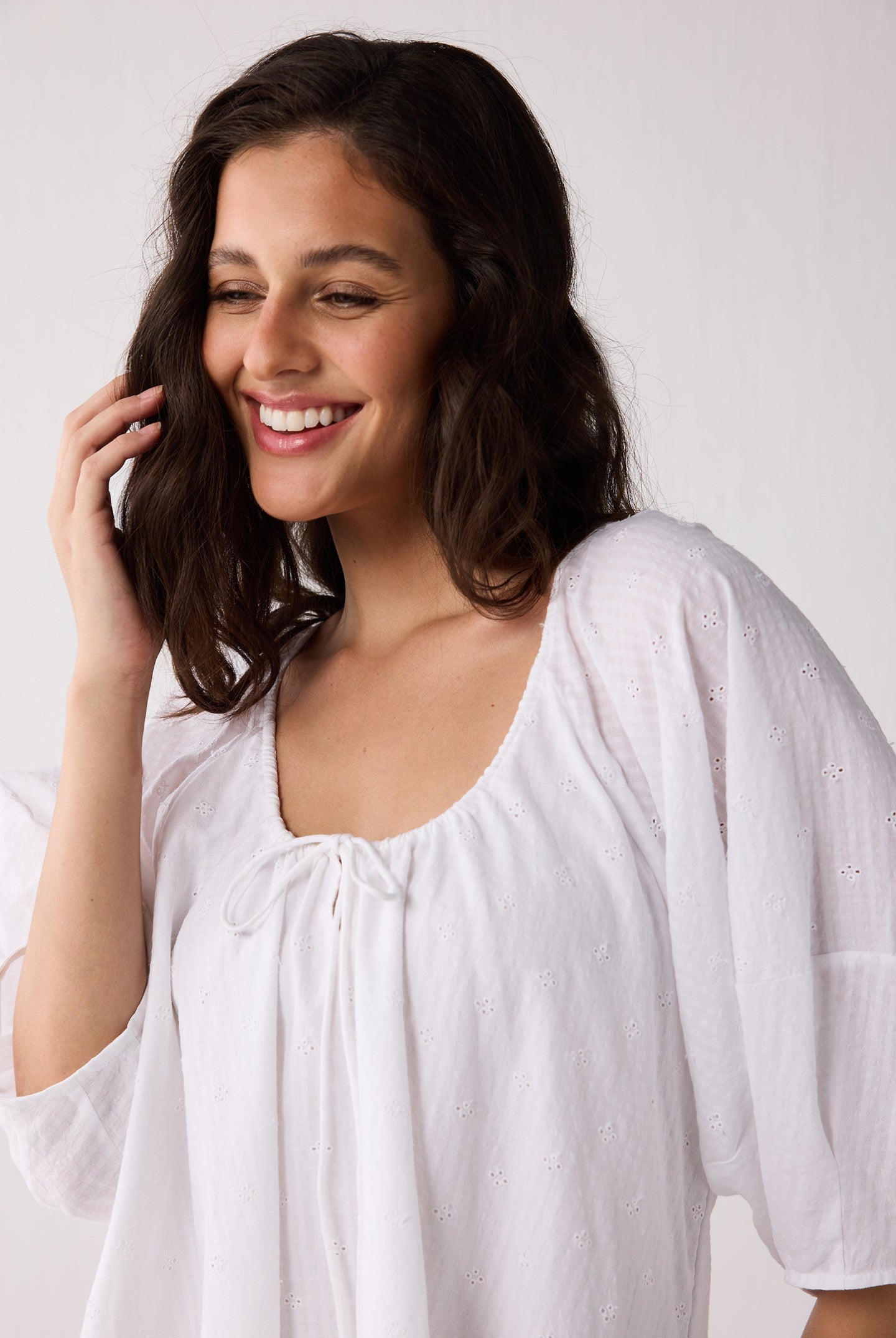 Woman wearing a white dress against a plain background