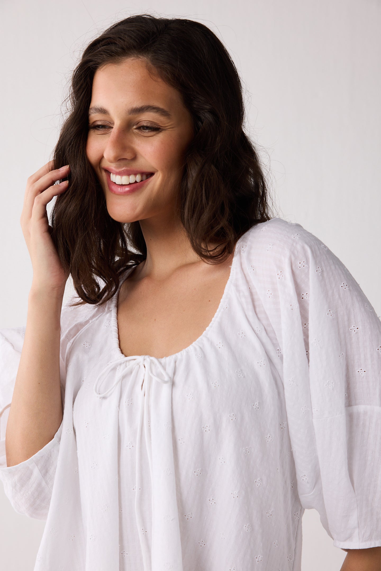 Woman wearing a white dress against a plain background
