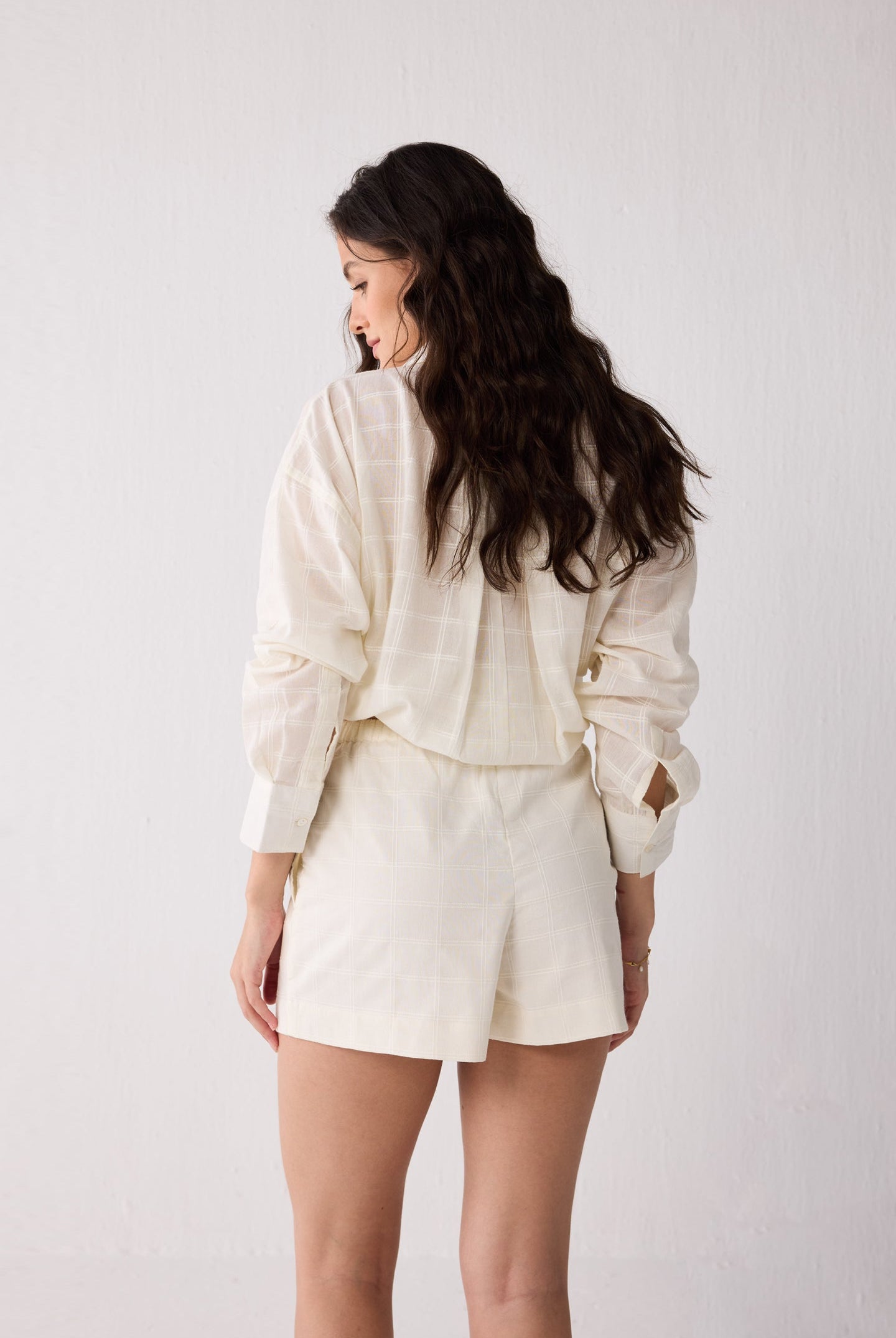 Woman wearing a white shorts against a plain background