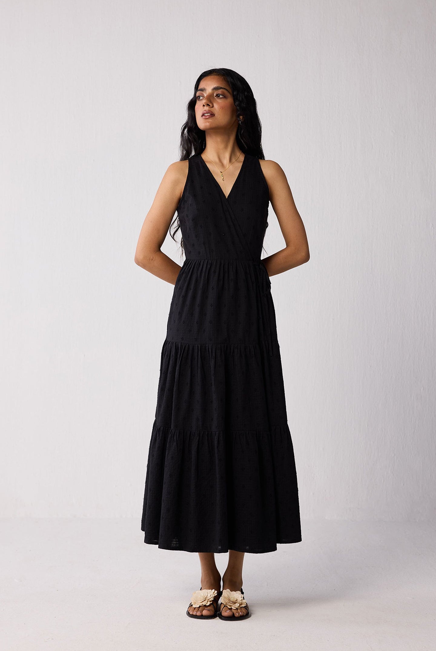 Woman wearing a black sleeveless dress against a white background