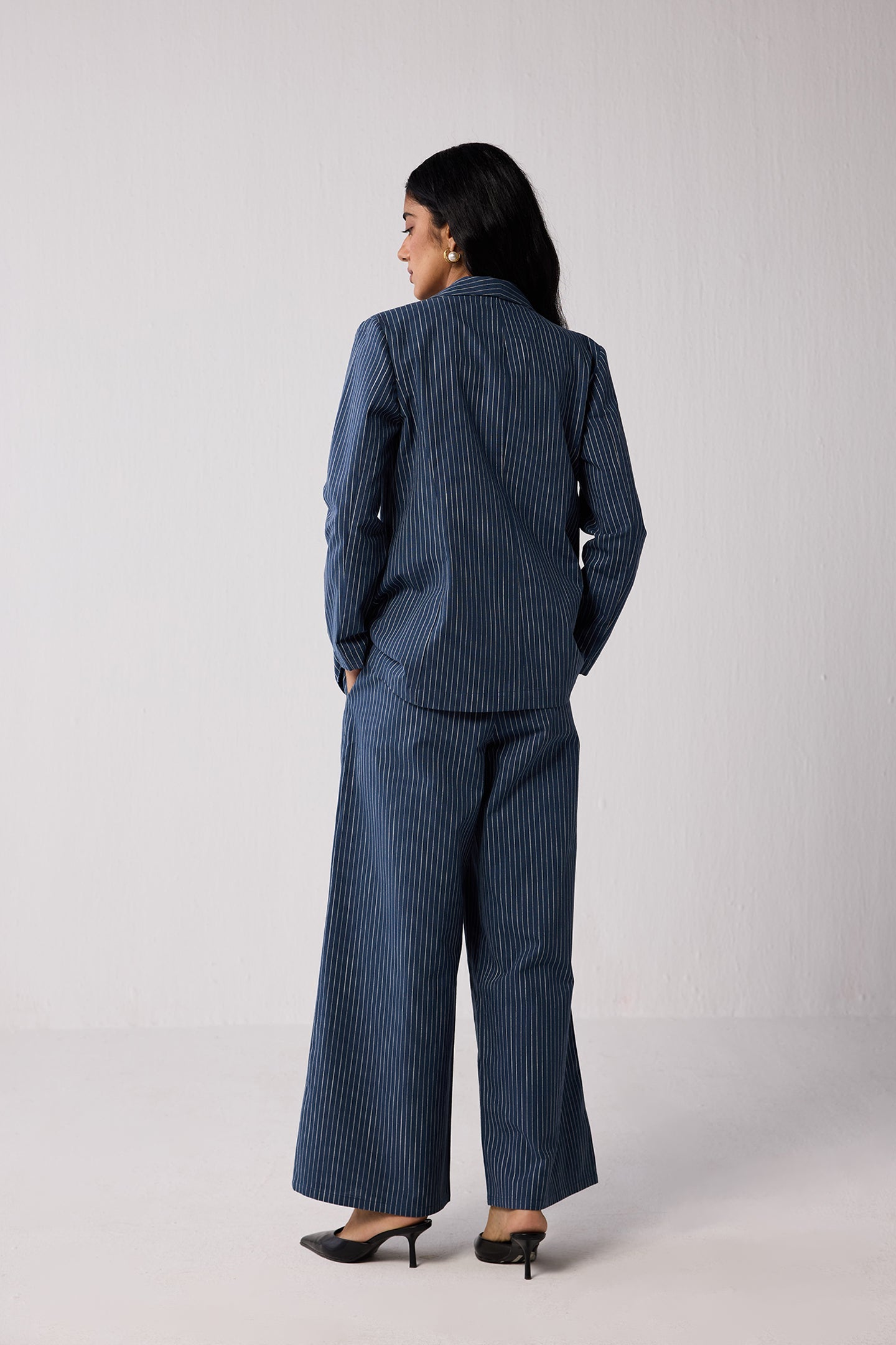 Woman wearing a blue pinstripe suit on a light background