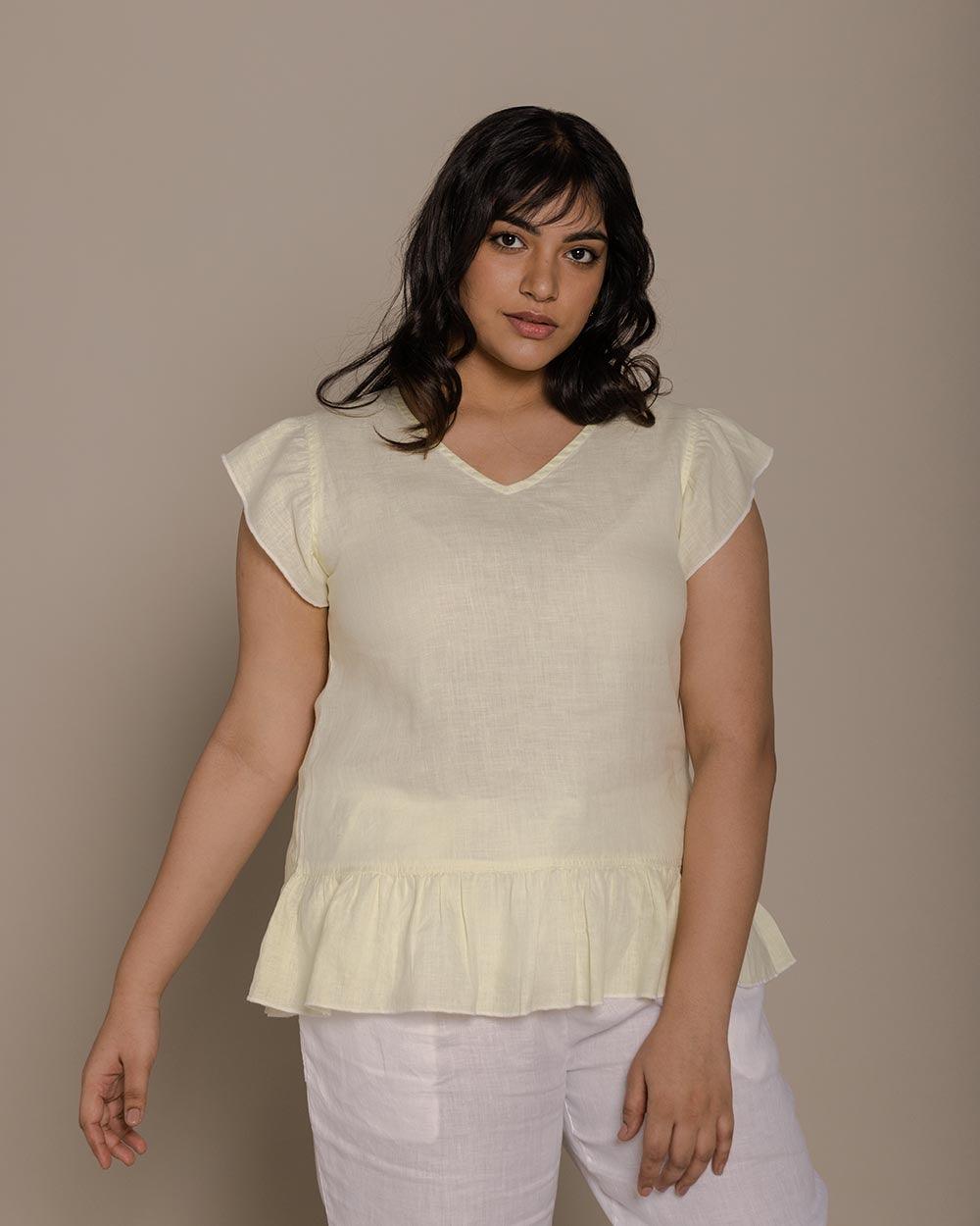 lemon yellow top with ruffled sleeves and a v neck.