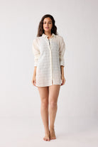 Woman wearing a white checkered shirt on a plain background