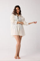Woman wearing a light-colored cover up on a white background