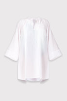 White beach cover-up with bell sleeves on a light gray background