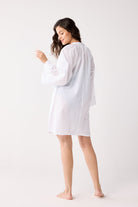 Woman wearing a white cover up on a white background