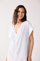 Woman wearing a white shirt against a plain background