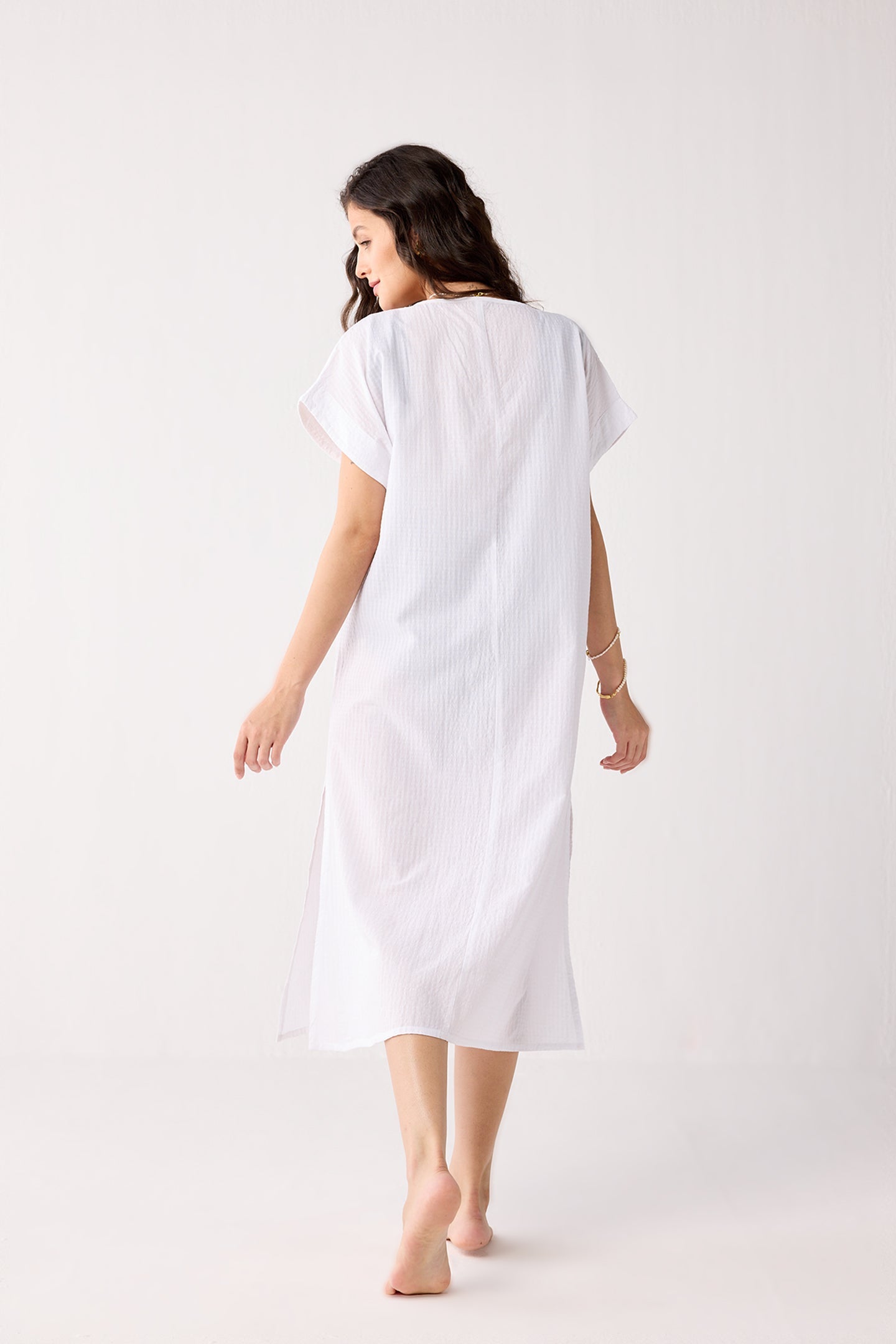 Woman wearing a white dress on a plain background