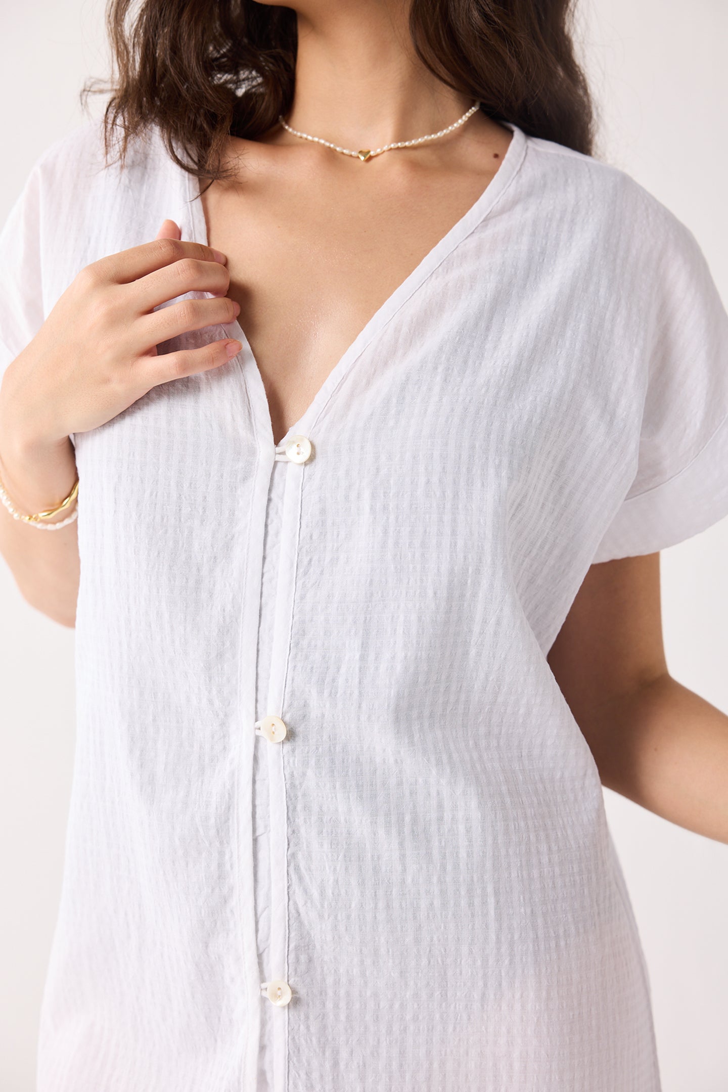 White button-up dress worn by a person on a white background