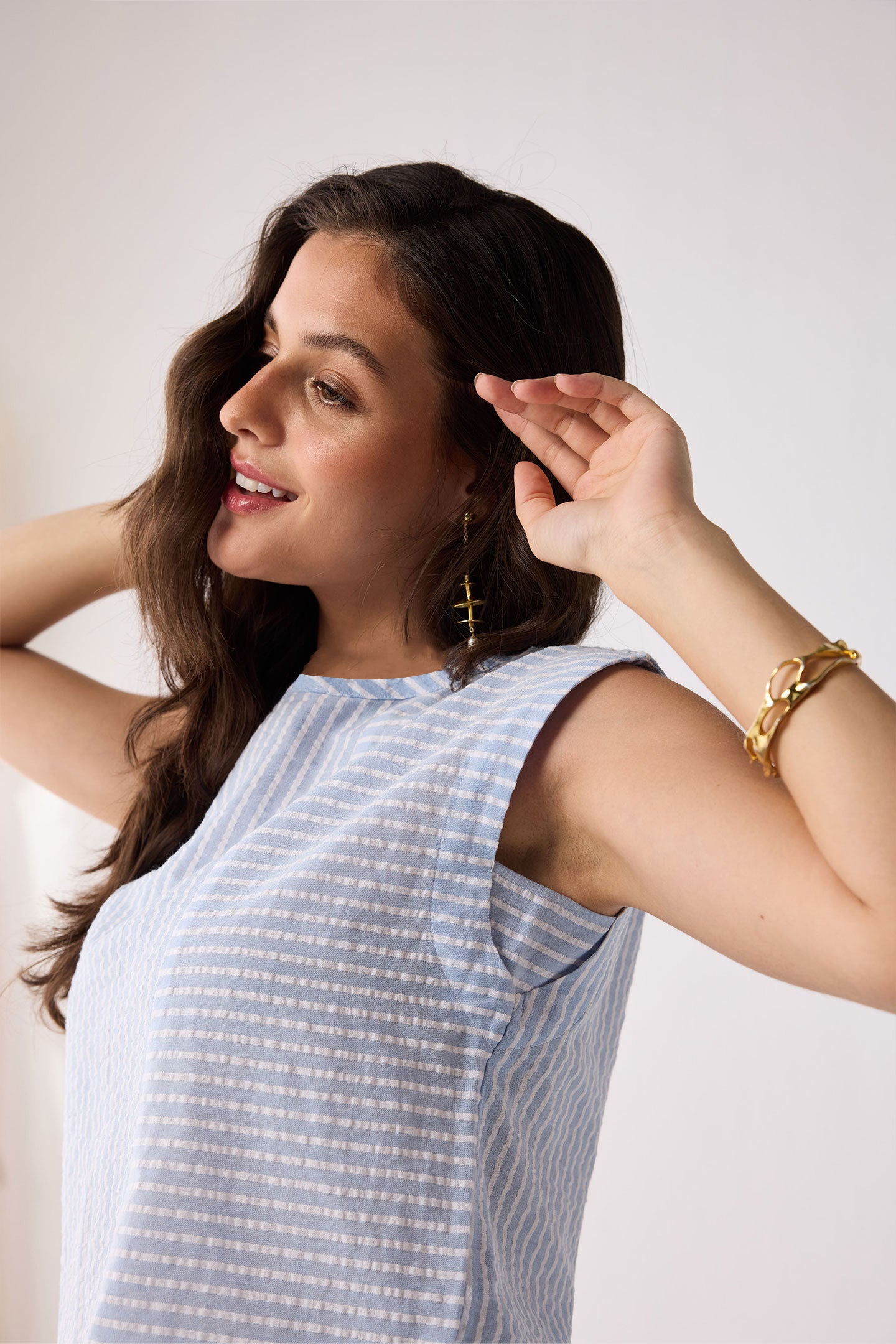 Woman wearing a light blue striped top with a white background