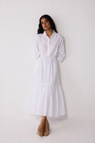 Woman wearing a white dress against a plain background