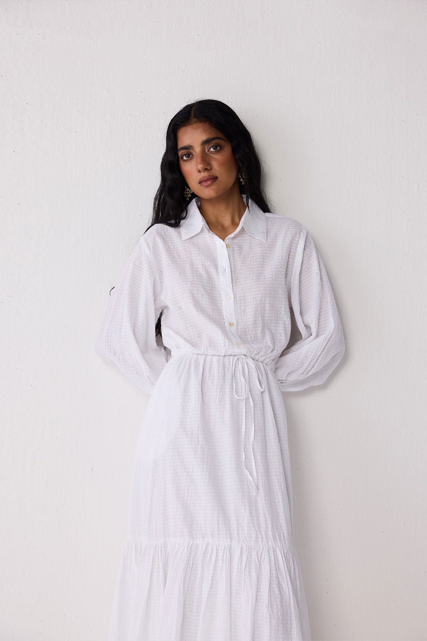 Woman wearing a white dress against a plain background