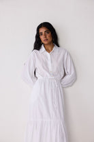 Woman wearing a white dress against a plain background