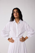 Woman wearing a white dress against a plain background