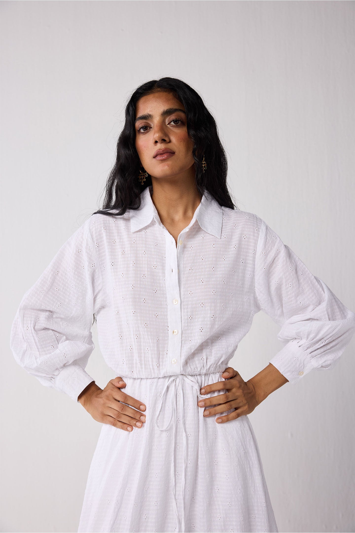 Woman wearing a white dress against a plain background