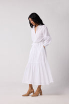 Woman wearing a white dress against a plain background