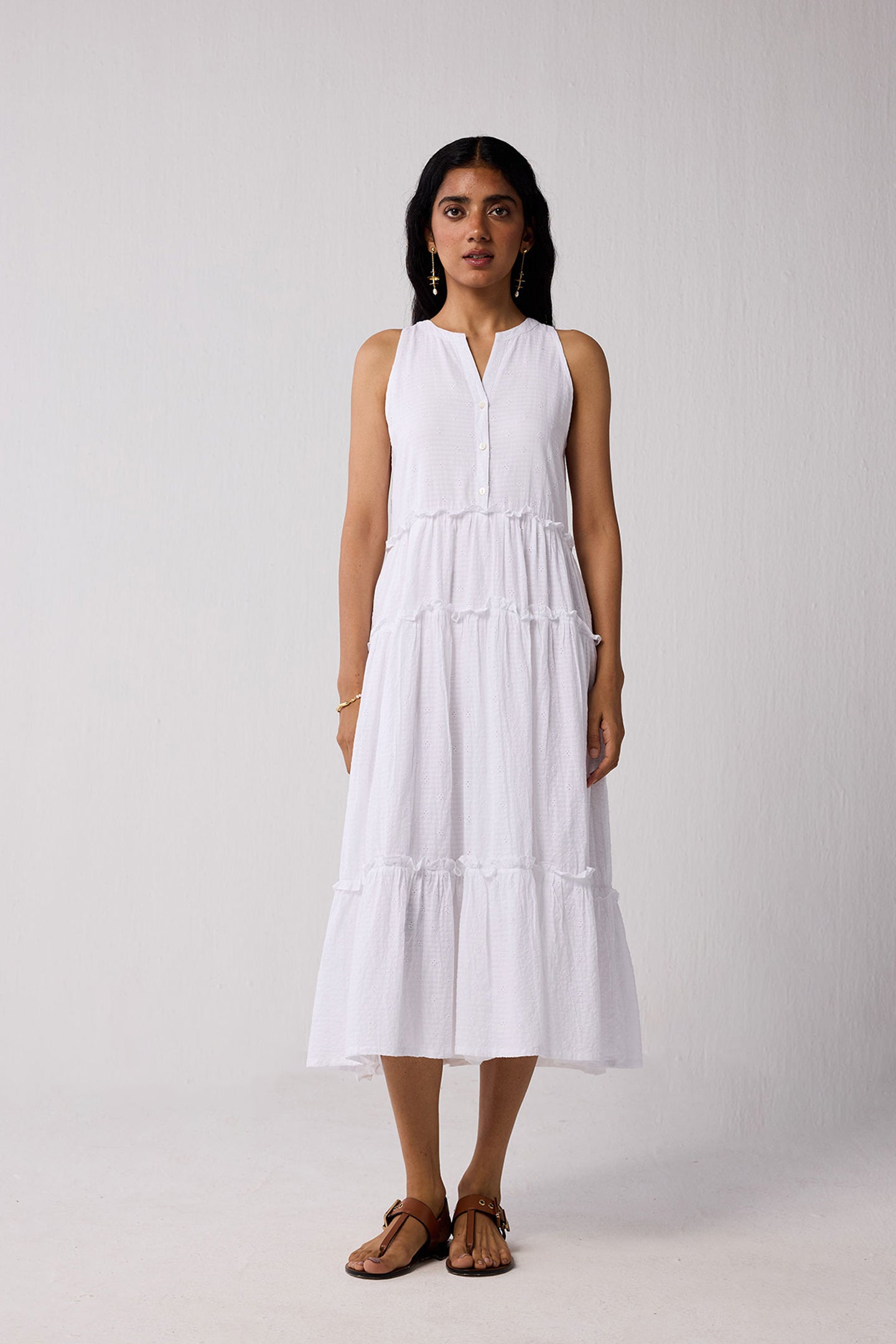 Woman wearing a white sleeveless dress on a plain background