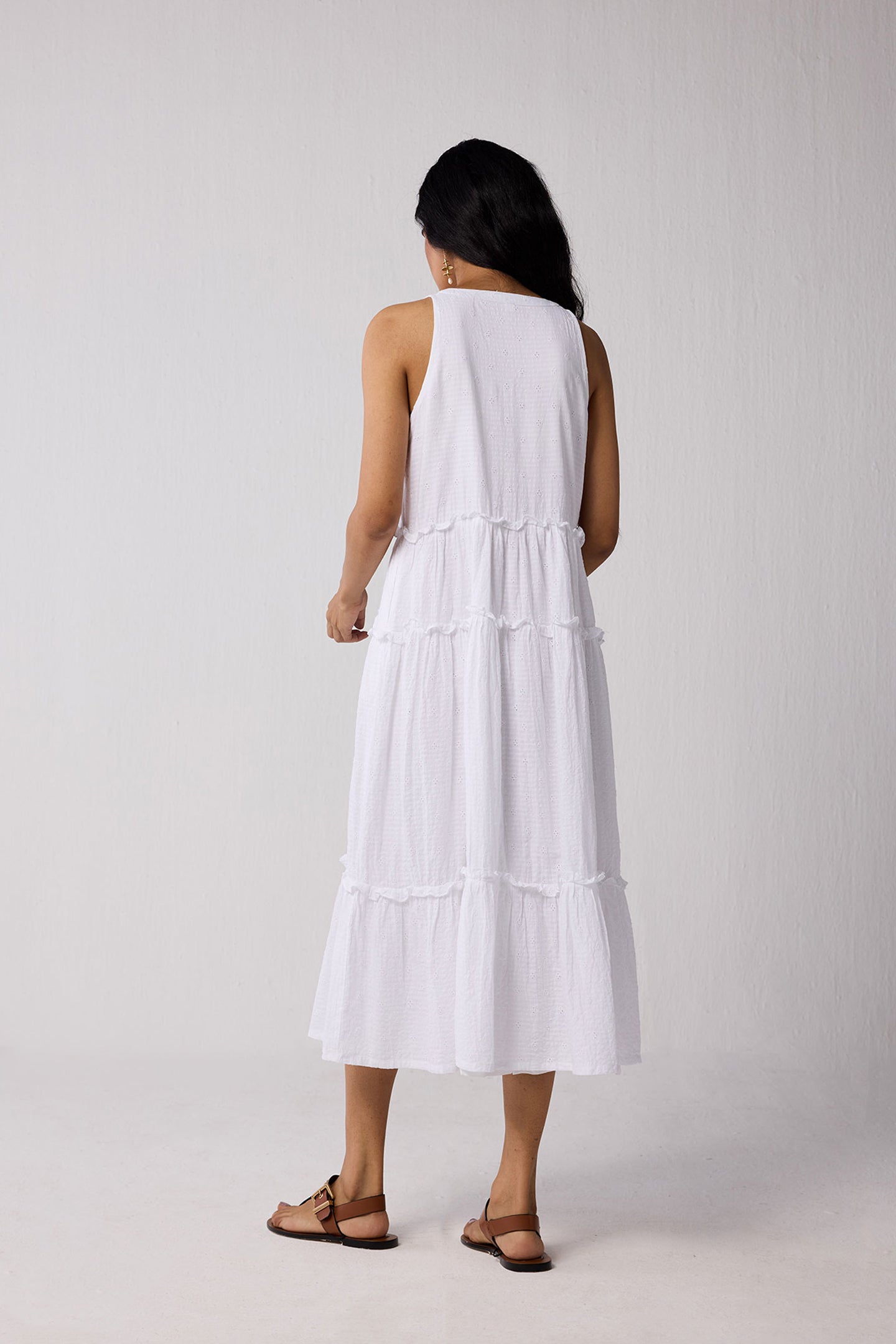 Woman wearing a white dress against a plain background