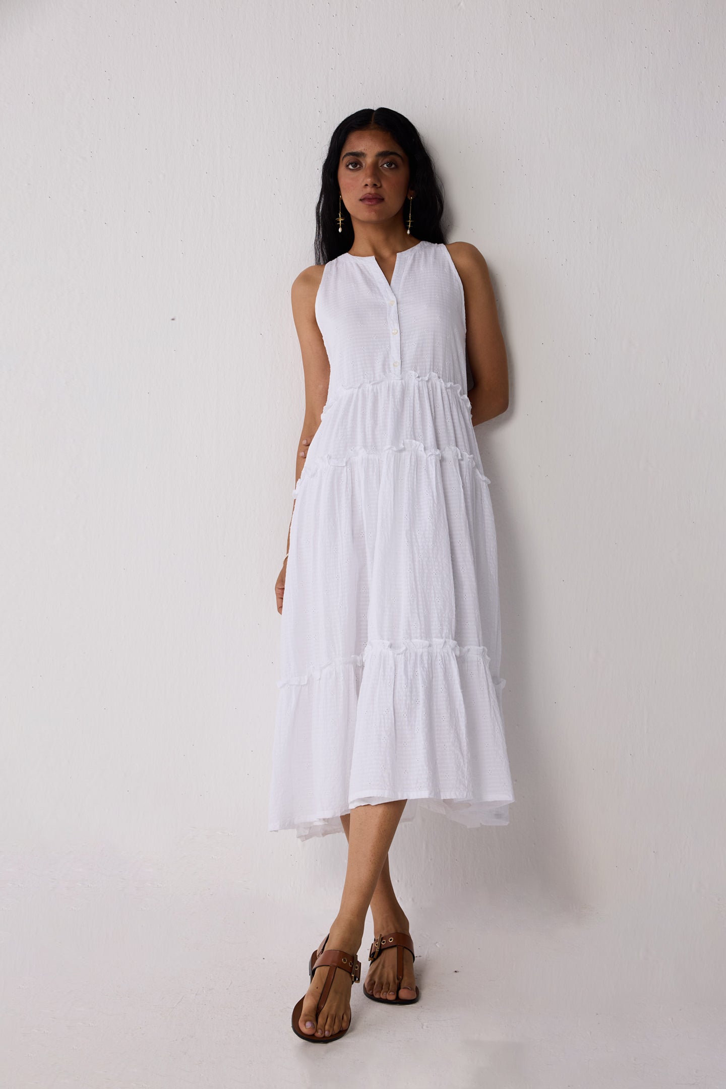 Woman wearing a white dress against a plain background
