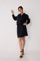 Woman wearing a black dress against a white background