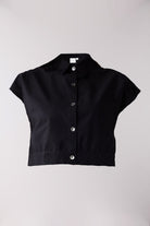 Black short-sleeve blouse with buttons on a light gray background