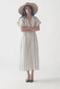 Model showcases Reistor striped maxi gathered dress with side slits, styled with a straw hat, presenting a front pose followed by a back pose to display the dress’s silhouette, gathered detailing, and flowing fabric.