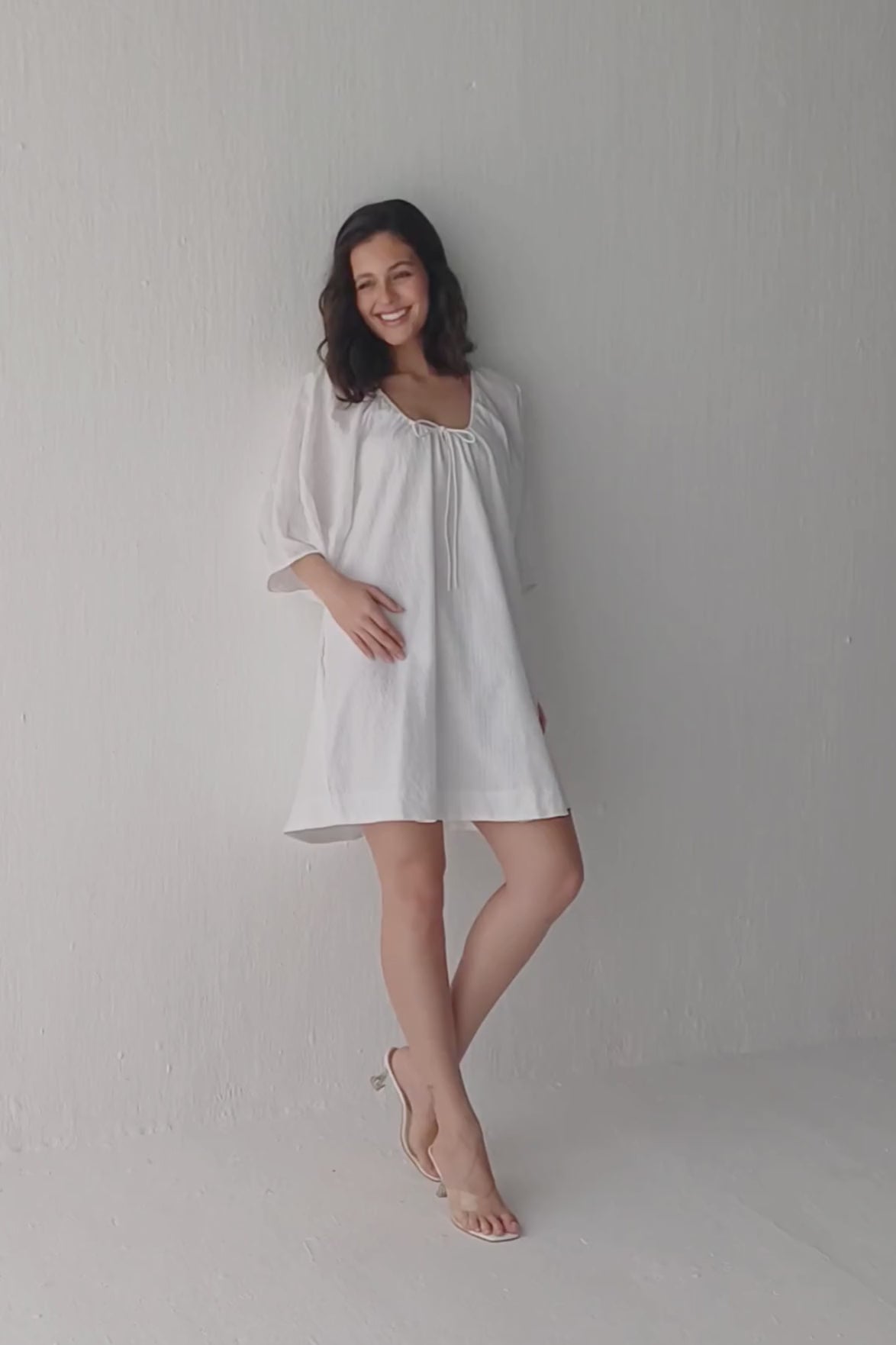 Fashion model wearing a Reistor puff-sleeved dress with a drawstring neckline, posing in various styles to display the adjustable neckline, airy sleeves, and flattering fit.