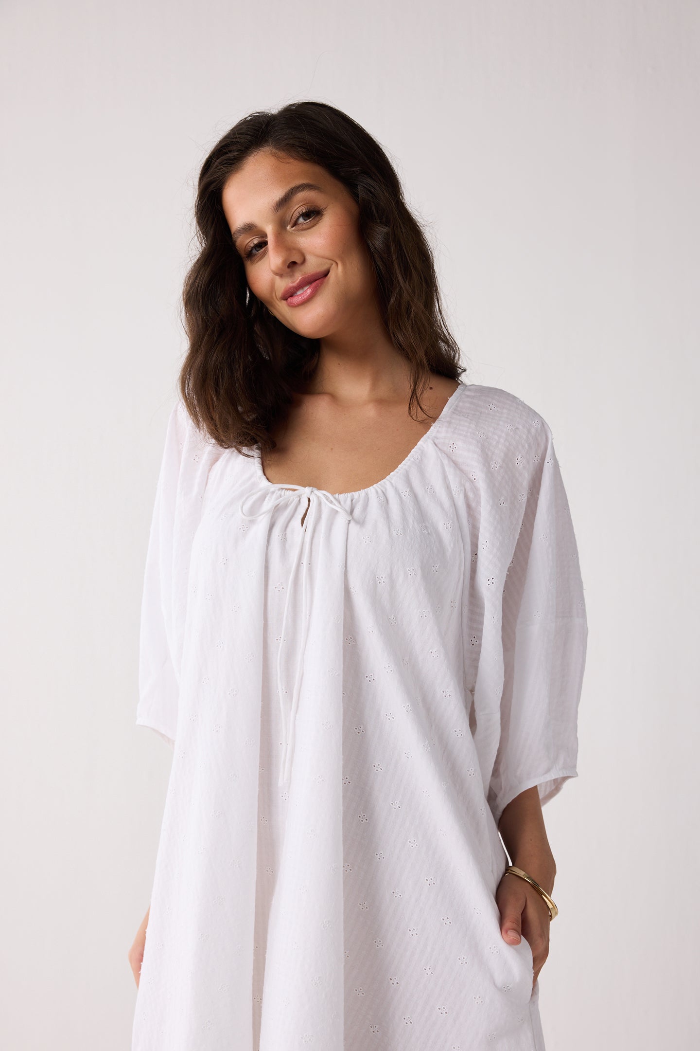 Woman wearing a white dress against a plain background