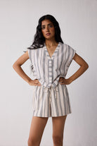 A woman wearing striped shorts against a plain background