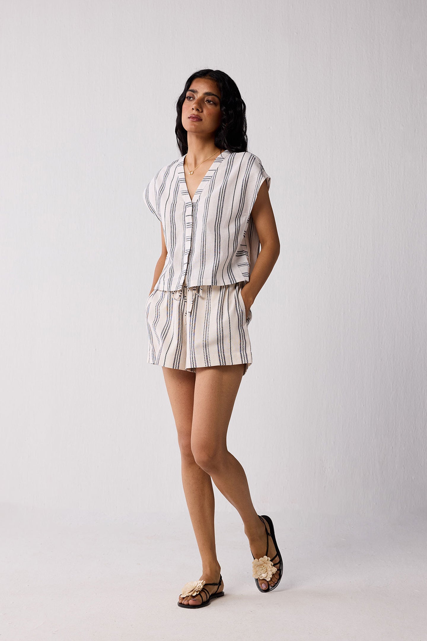 Woman wearing a striped shirt and shorts set against a plain background