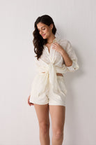 Woman wearing a white shorts against a plain background