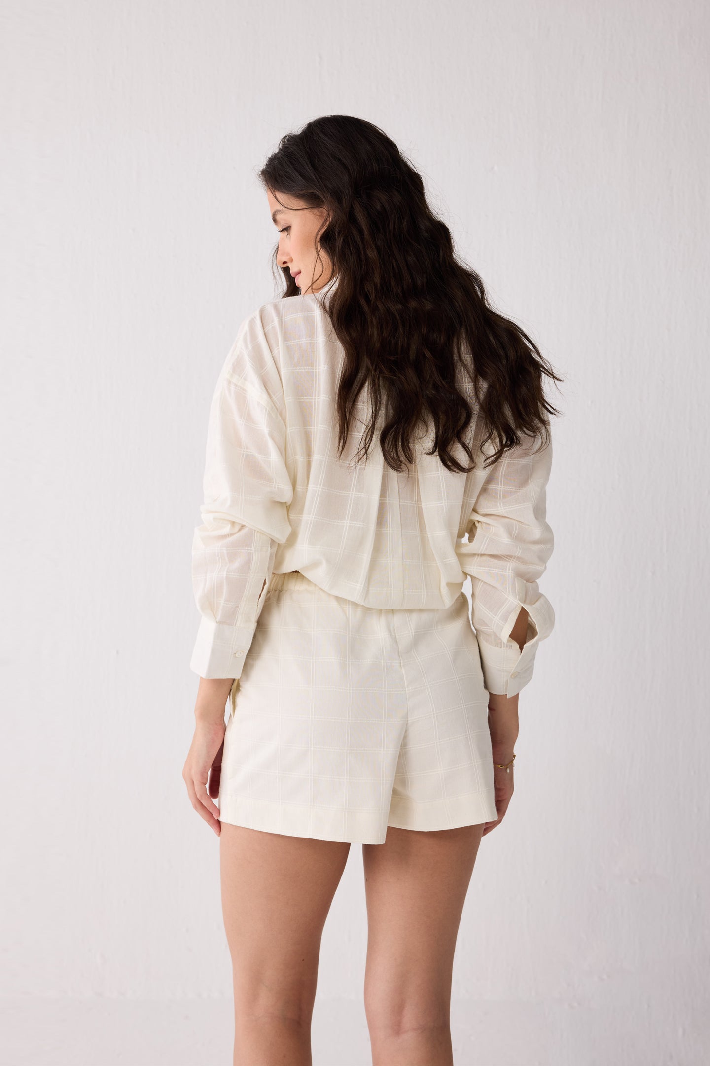 Woman wearing a white shorts against a plain background