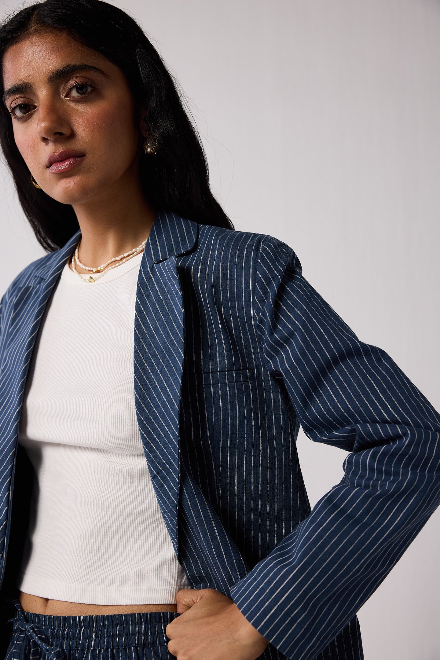 Woman wearing a blue pinstripe suit  on a light background