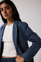 Woman wearing a blue pinstripe suit  on a light background